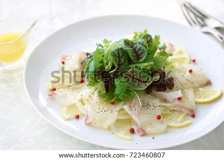  Fresh sea bream carpaccio with salad on white plate