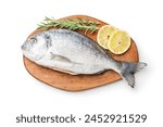 Fresh sea bream fish, rosemary and lemon on cutting board isolated on a white background.