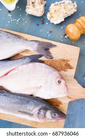fresh sea fish preparation - dorada and seabass choise of fresh fish on cutting board closeup