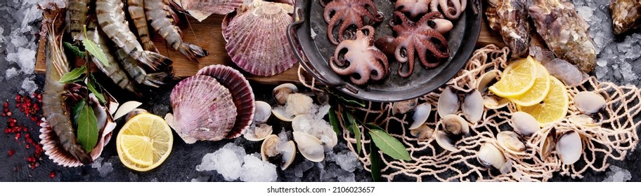Fresh seafood arrangement on dark background. Mediterranean diet concept. Flat lay, top view, panorama 