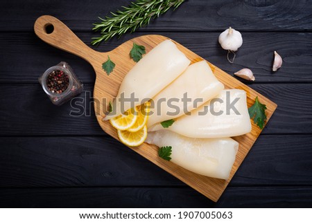 Fresh seafood background .  Squid tubes with lemon 