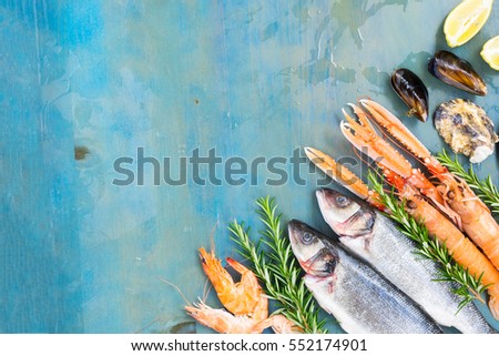 Fresh seafood and fish flat lay scene on blue background with copy space