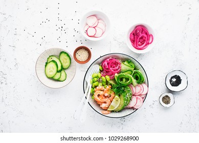 Fresh seafood recipe. Shrimp poke bowl with fresh prawn, brown rice, cucumber, pickled sweet onion, radish, soy beans edamame portioned with black and white sesame. Food concept poke bowl