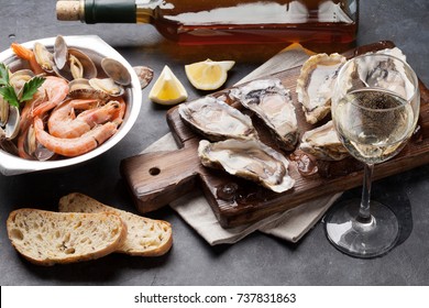 Fresh seafood and white wine on stone table