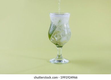 Fresh Seltzer Water Is Poured Into A Glass With Mint And Ice. Refreshing Drinks In The Heat