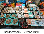 Fresh shellfish for sale in Jagalchi Fish Market under available light