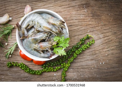 Fresh Shrimp On White Bowl And Wooden Background With Ingredients Herb And Spices For Cooking Seafood / Raw Shrimps Prawns