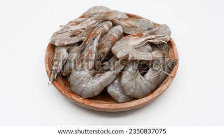 Fresh shrimp tails isolated. Raw headless prawn, pacific shrimp, uncooked tiger prawns, jumbo seafood on wooden bowl