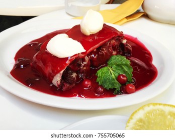 A fresh slice of cherry pie with cherry jam on a white plate. Close up shot