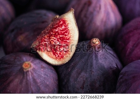 Fresh slice of fig lying on a heap of ripe figs. Heap of tasty organic figs ストックフォト © 