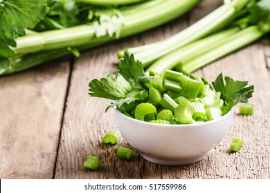 Fresh sliced celery in a white bowl on a vintage wooden background, selective focus - Shutterstock ID 517559986