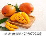 Fresh sliced, cut, diced ripe mango on gray table background with leaf for eating.