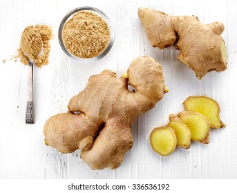 Fresh Sliced Ginger Root And Ground Ginger On White Wooden Background; Top View