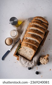 Fresh Sliced Homemade Wholegrain Wheat Bread whit olive oil on white rustic background. Artisan Sourdough