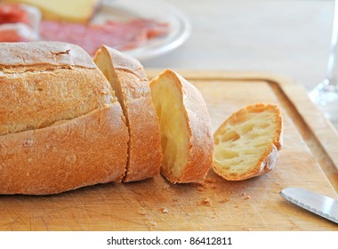 Fresh sliced Italian bread on wooden breadboard, shallow depth of field