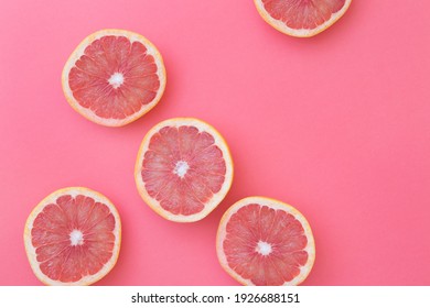 Fresh slices of natural grapefruit on pink background - Shutterstock ID 1926688151