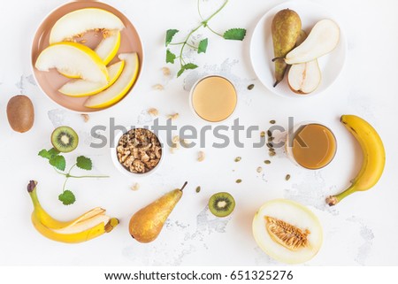 Fresh smoothie with pear, banana, melon, kiwi. Summer fruit cocktail on white table. Vegan, vegetarian, detox, dieting concept. Flat lay, top view