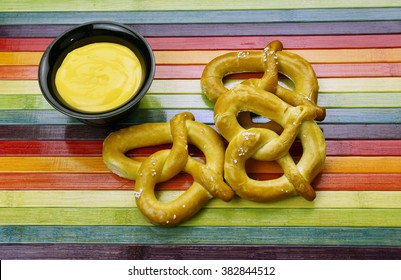 Fresh Soft Pretzel With Hot Cheese Fondue On A Rainbow Background