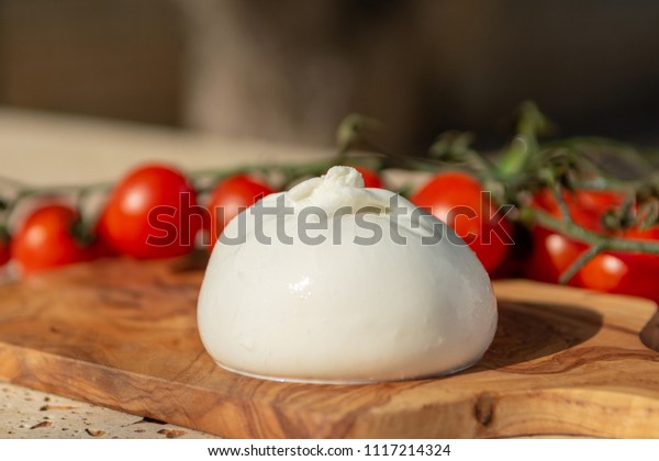 Fresh soft white burrata, buttery cheese, made\
from a mix of mozzarella and cream, original from Apulia region,\
Italy with tomatoes