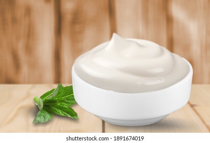 Fresh Sour Cream Yogurt In Glass Bowl And Basil Leaves