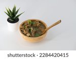 Fresh spicy lamb paya soup in a wooden bowl and ready to eat. Home made mutton soup called paya or attukaal soup in south india. Mutton soup in wooden bowl

