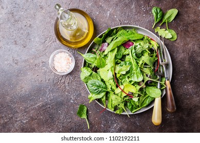 Fresh Spring Green Salad With Mix Of Spinach, Arugula, Romaine And Lettuce On A Plate Over Dark Background, Top View