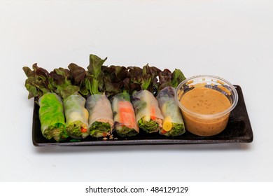 Fresh spring roll multi stuffs with salad source on black plate.