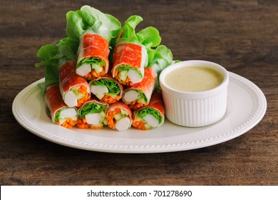Fresh spring rolls or salad rolls made with fresh vegetable, crab stick and Vietnamese rice paper, serve with spicy salad cream dipping on white plate.Healthy and delicious for appetizer. Fusion food.