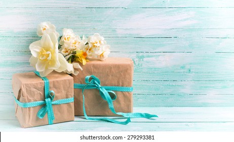 Fresh  spring white and pink  tulips and narcissus in grey bucket, heart, candles in decorative bird cages in ray of light  on white painted wooden background against turquoise wall. Selective focus.  - Powered by Shutterstock