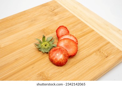 Fresh starwberries in slices on chopping board top angle