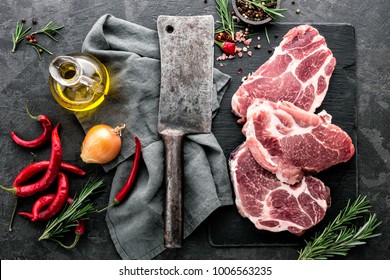 Fresh Steaks From Raw Pork Meat On Dark Stone Background, Top View