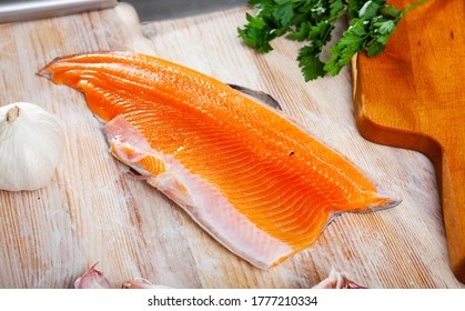 Fresh Steelhead Trout Fillet On Wooden Surface With Seasonings Ready For Cooking