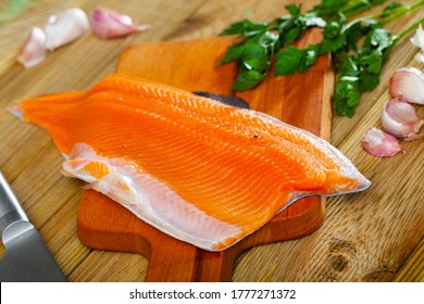 Fresh Steelhead Trout Fillet On Wooden Surface With Seasonings Ready For Cooking