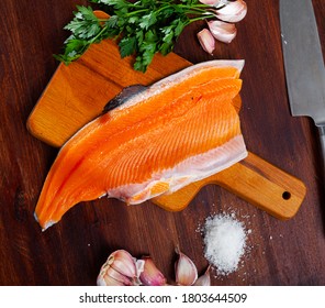 Fresh Steelhead Trout Fillet On Wooden Surface With Seasonings Ready For Cooking