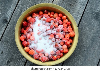 fresh strawberries in a copper bowl with sugar, jam preparation. jam cooking