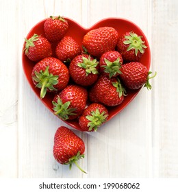 Fresh strawberries on a plate in the shape of heart