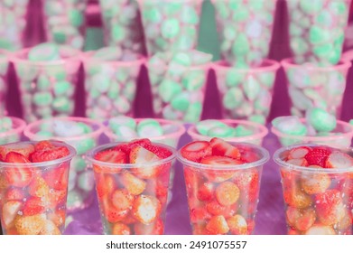 Fresh strawberries in plastic cups on a fruit stand. Fresh organic vegetables on farmer market in Thailand. Organic strawberries packed in plastic cups. - Powered by Shutterstock