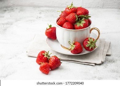Fresh strawberries in a white cup on marble white table. Fresh nice strawberries. Strawberry field on fruit farm. Heap of Red strewberry on plate. Juice strawberry. Strawberry field on fruit farm.