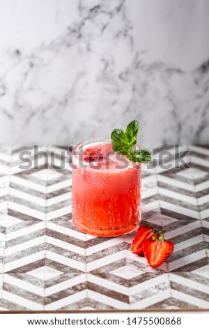 Fresh strawberry cocktail. Fresh summer cocktail with strawberry and ice cubes. Stawberry lemonade with leaves of mint.