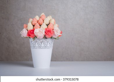Fresh strawberry covered by pink and white chocolate with rose flowers designed as a fruit bouquet in a vase, with copy space