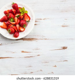 Fresh Strawberry on White Plate and Rustic Wooden Background. Summer Concept, Top View, Copy Space for Text