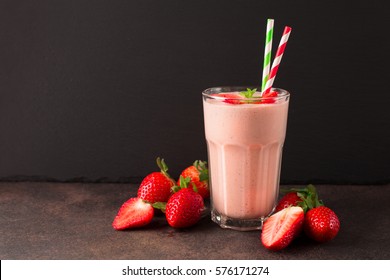 Fresh strawberry smoothie or milkshake and berries on old retro background. View with copy space, selective focus. Healthy Eating concept