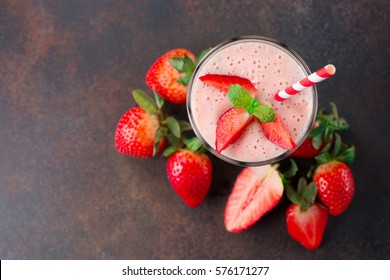 Fresh strawberry smoothie or milkshake and berries on old retro background. Top view with copy space. Healthy Eating concept