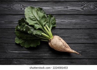 Fresh sugar beet with leaves on black wooden table, top view - Powered by Shutterstock