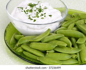 Fresh Sugar Snap Peas On A Green Plate With A Side Of Sour Cream Dip