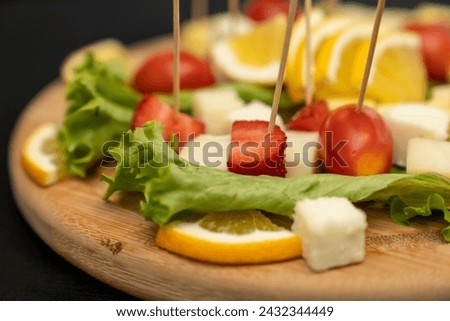 Fresh summer fruit kebab on a slate plate. vitamin sweet food background. Delicious appetizers with cheese and mix ingredients. fruit salad with fresh berries and fruits
