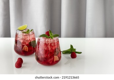 Fresh Summer Lemonade With Raspberry, Lime, Soda Water, And Ice In Glasses. Cold Refreshing Drink, Cocktail Or Mocktail.