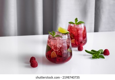 Fresh Summer Lemonade With Raspberry, Lime, Soda Water, And Ice In Glasses. Cold Refreshing Drink, Cocktail Or Mocktail.