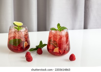 Fresh Summer Lemonade With Raspberry, Lime, Soda Water, And Ice In Glasses. Cold Refreshing Drink, Cocktail Or Mocktail.