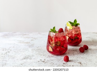 Fresh summer lemonade with raspberry, lime, soda water, and ice in glasses. Cold refreshing drink, cocktail or mocktail. - Powered by Shutterstock